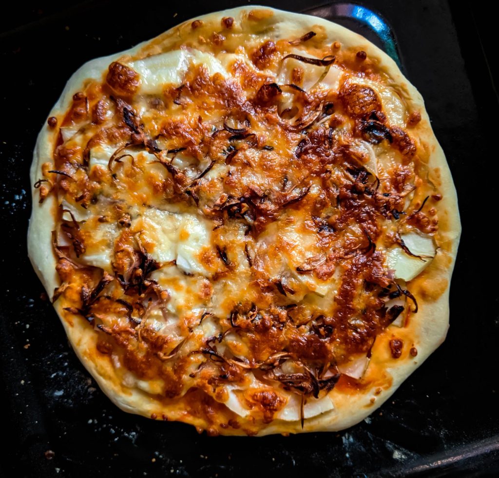 pizza topped with sliced potatoes and caramelized onions